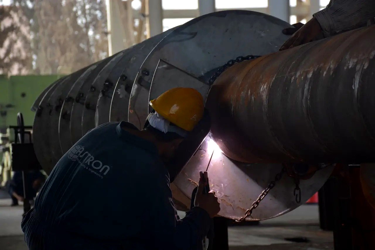 Astron worker welding large cylindrical component